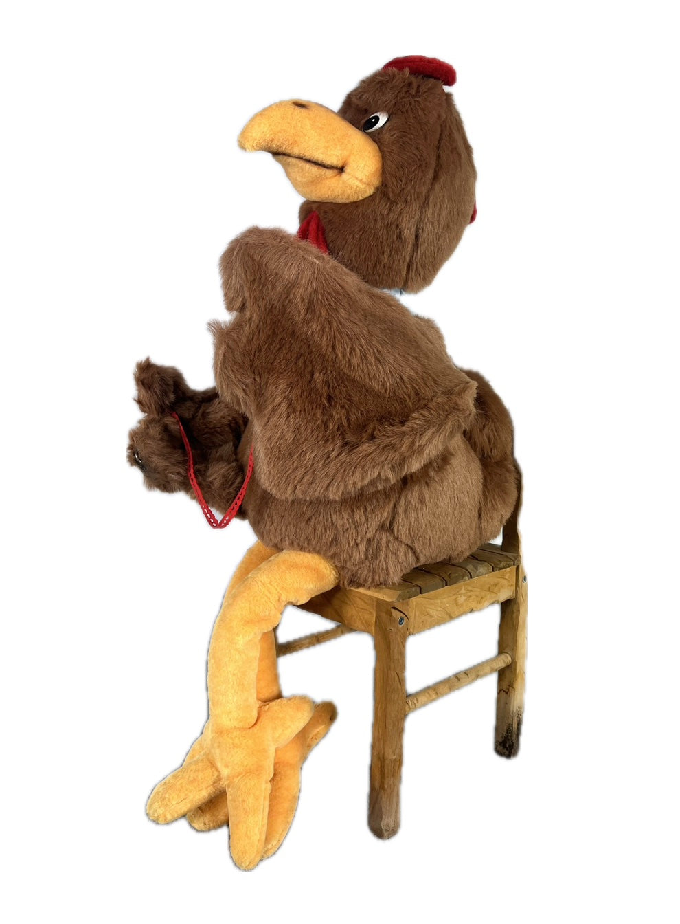 Huhn mit Halstuch sitzt auf Hocker