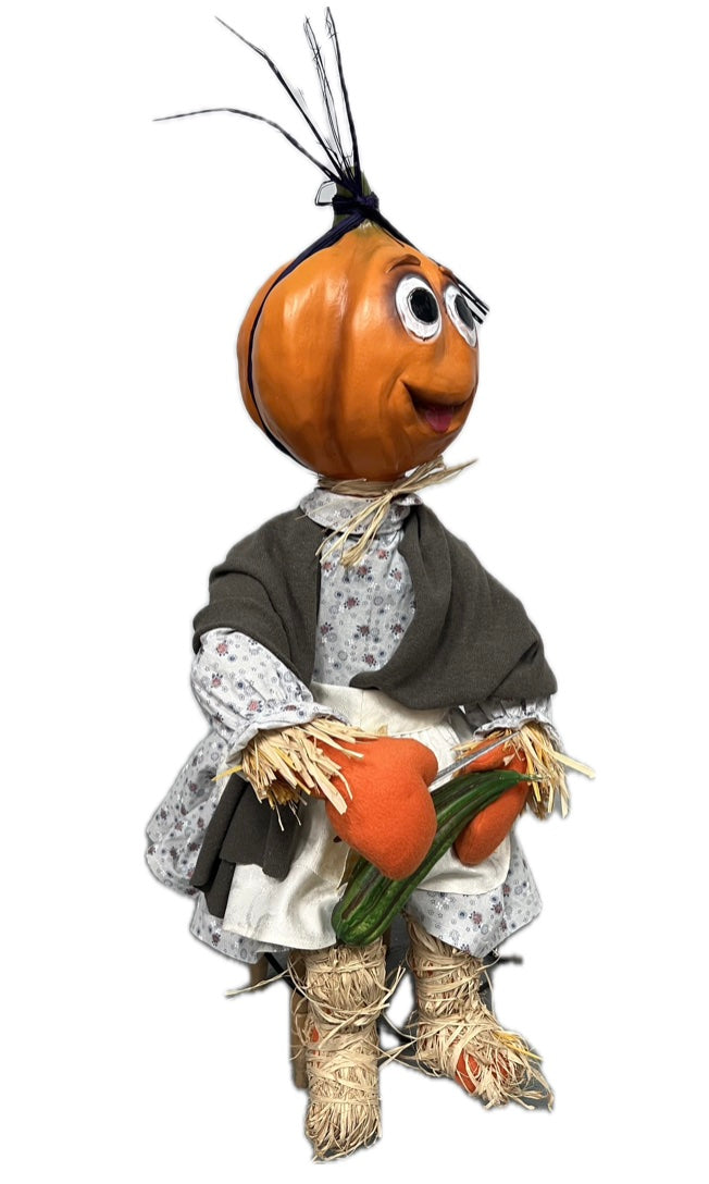 Kürbismädchen sitzend mit Gurke