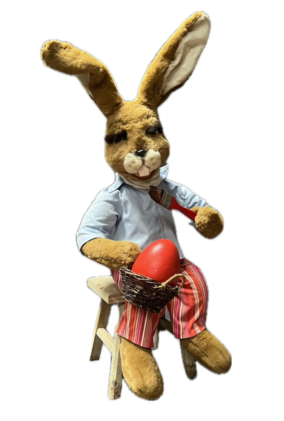 Hase sitzend mit Pinsel malt Ei rot an