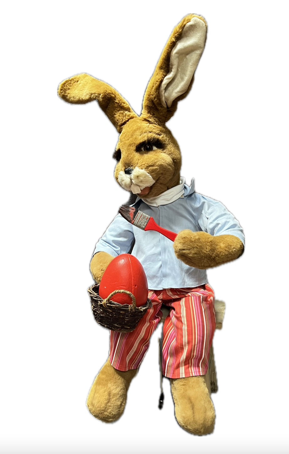 Hase sitzend mit Pinsel malt Ei rot an