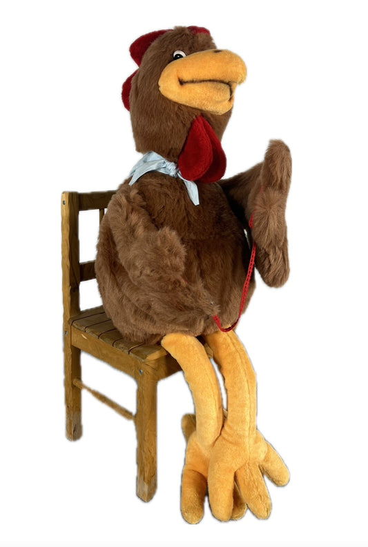 Huhn mit Halstuch sitzt auf Hocker