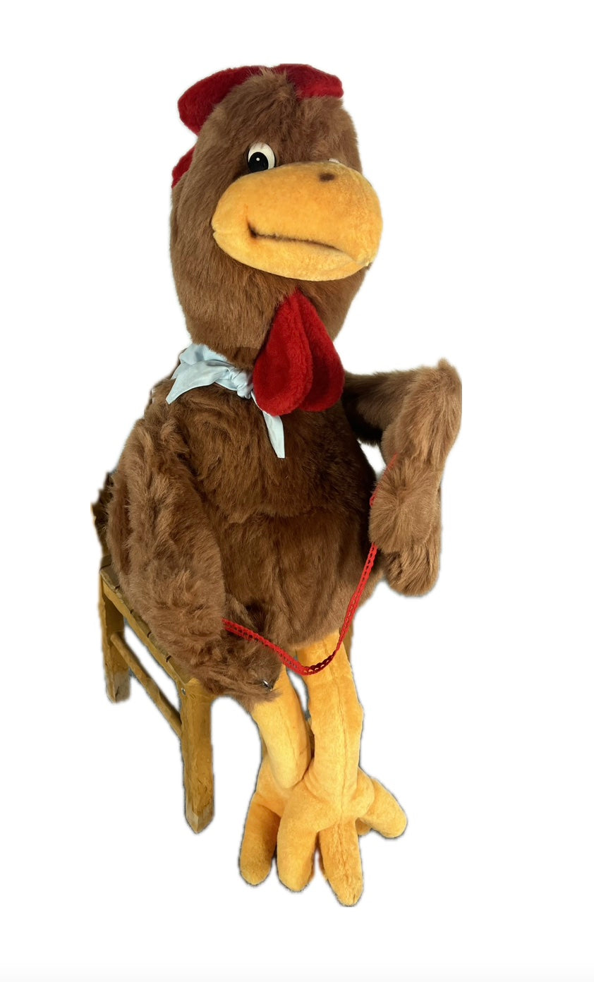 Huhn mit Halstuch sitzt auf Hocker