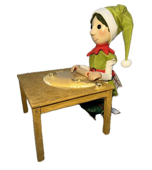 Elf mit Knopfaugen rollt Teig aus (Weihnachtsbäckerei)