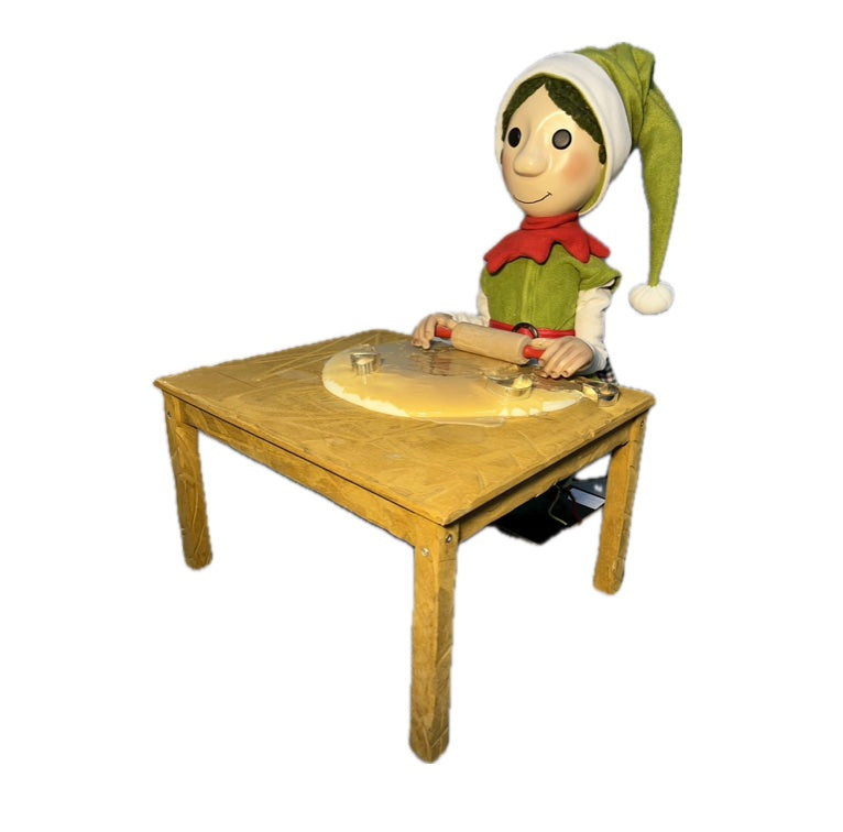 Elf mit Knopfaugen rollt Teig aus (Weihnachtsbäckerei)