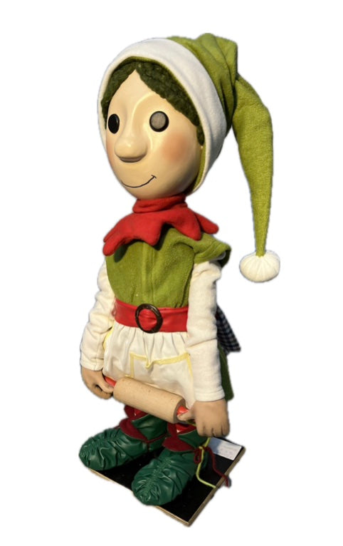 Elf mit Knopfaugen rollt Teig aus (Weihnachtsbäckerei)