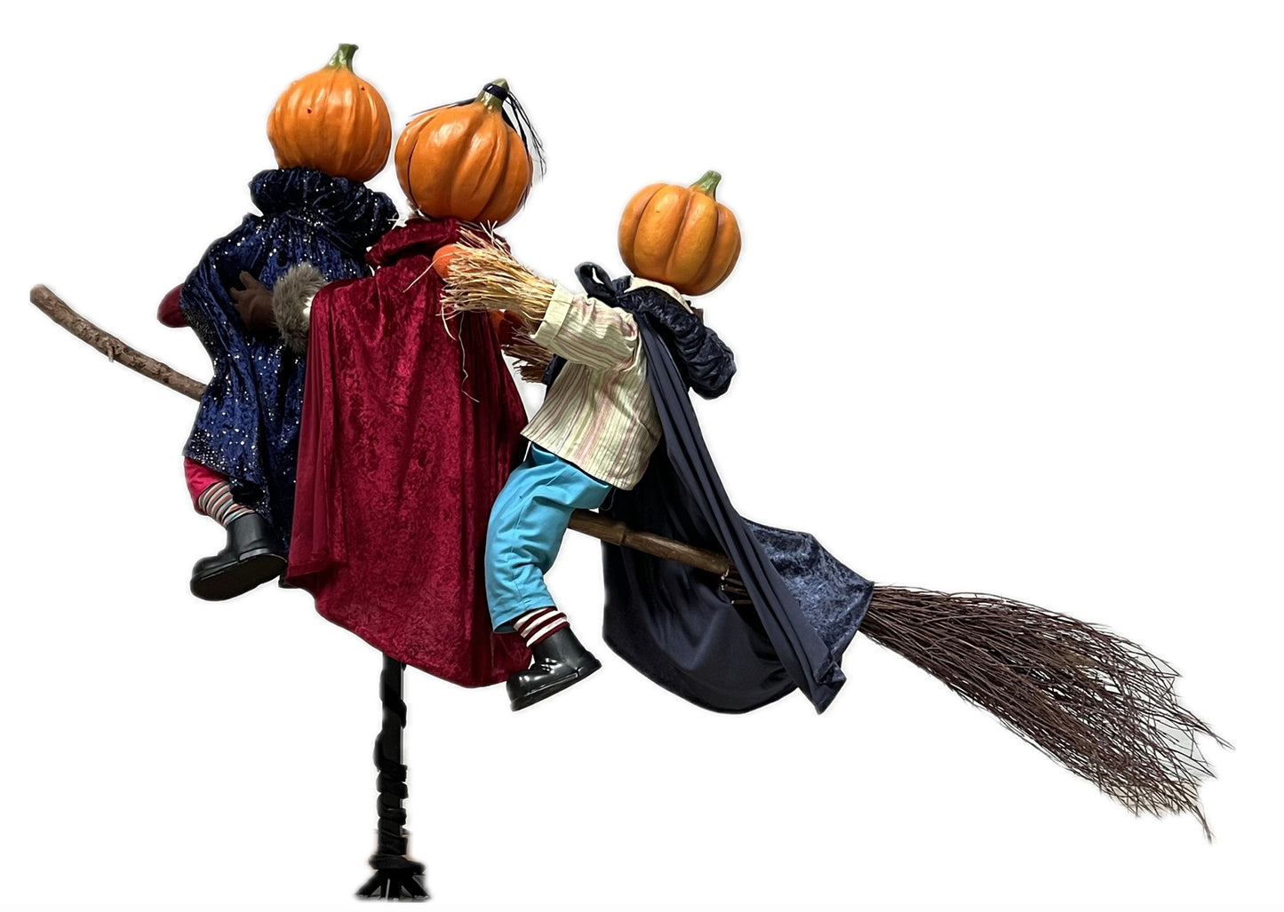 3 Kürbisfiguren fliegen auf einem Hexenbesen