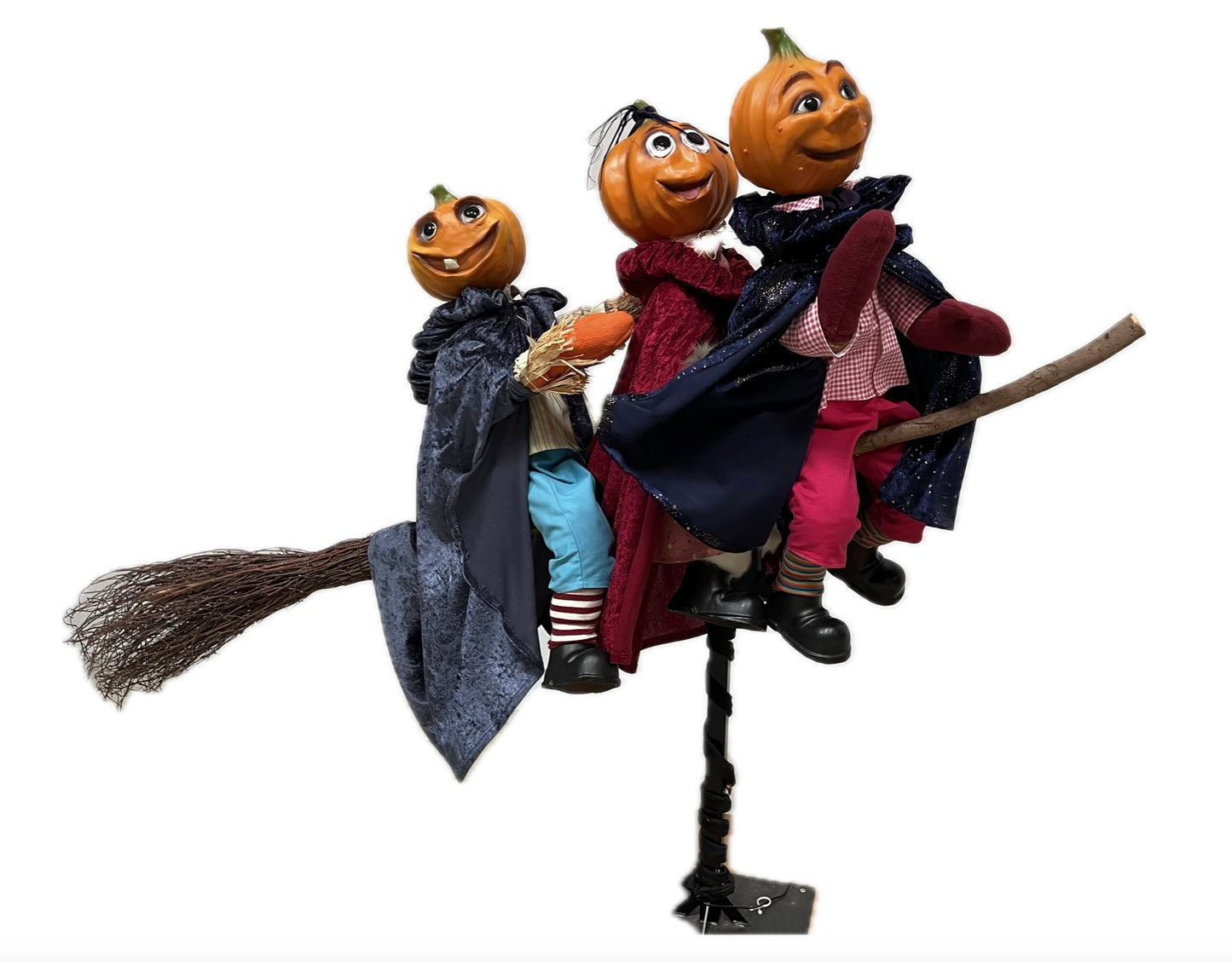 3 Kürbisfiguren fliegen auf einem Hexenbesen