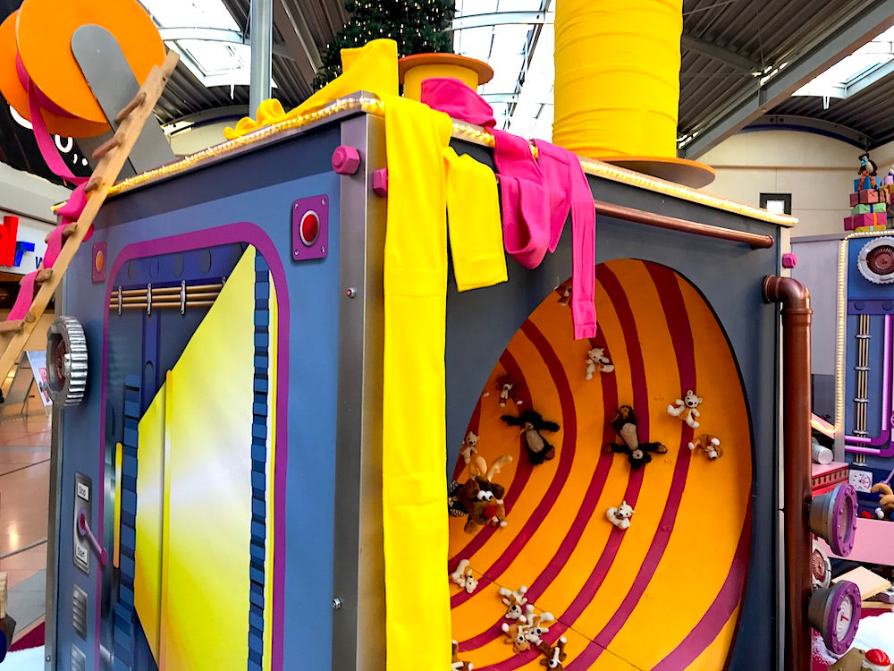 Rudis Rentiertrupp verpackt Weihnachtsgeschenke mit einer großen Maschine