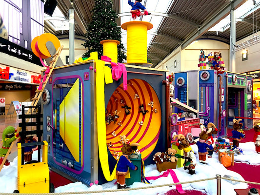 Rudis Rentiertrupp verpackt Weihnachtsgeschenke mit einer großen Maschine