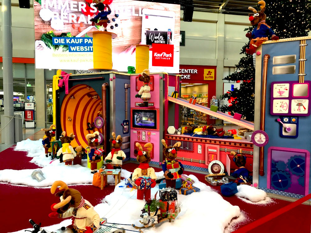 Rudis Rentiertrupp verpackt Weihnachtsgeschenke mit einer großen Maschine