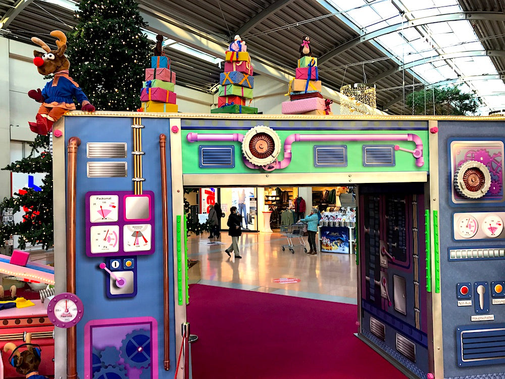 Rudis Rentiertrupp verpackt Weihnachtsgeschenke mit einer großen Maschine