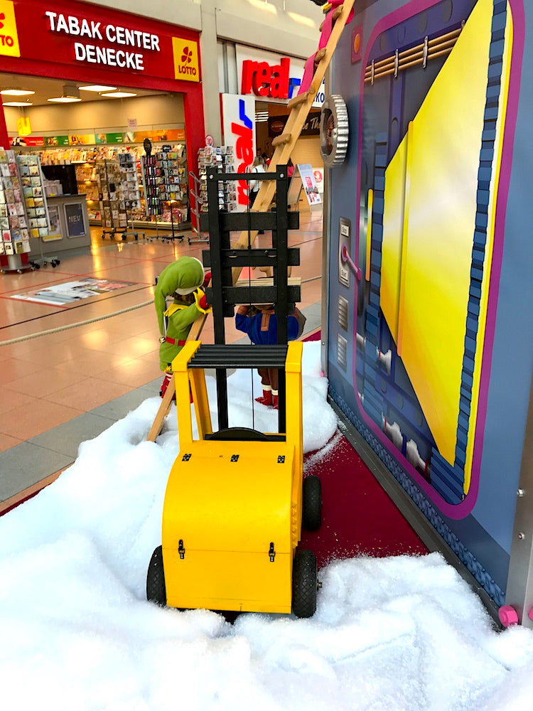 Rudis Rentiertrupp verpackt Weihnachtsgeschenke mit einer großen Maschine