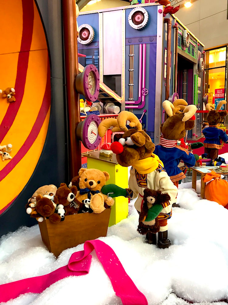 Rudis Rentiertrupp verpackt Weihnachtsgeschenke mit einer großen Maschine