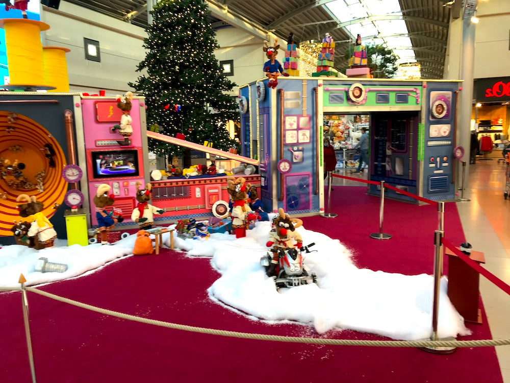 Rudis Rentiertrupp verpackt Weihnachtsgeschenke mit einer großen Maschine