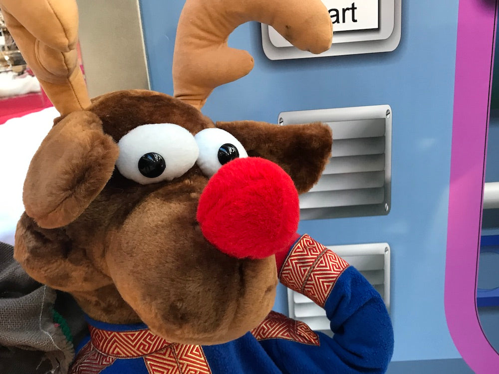 Rudis Rentiertrupp verpackt Weihnachtsgeschenke mit einer großen Maschine