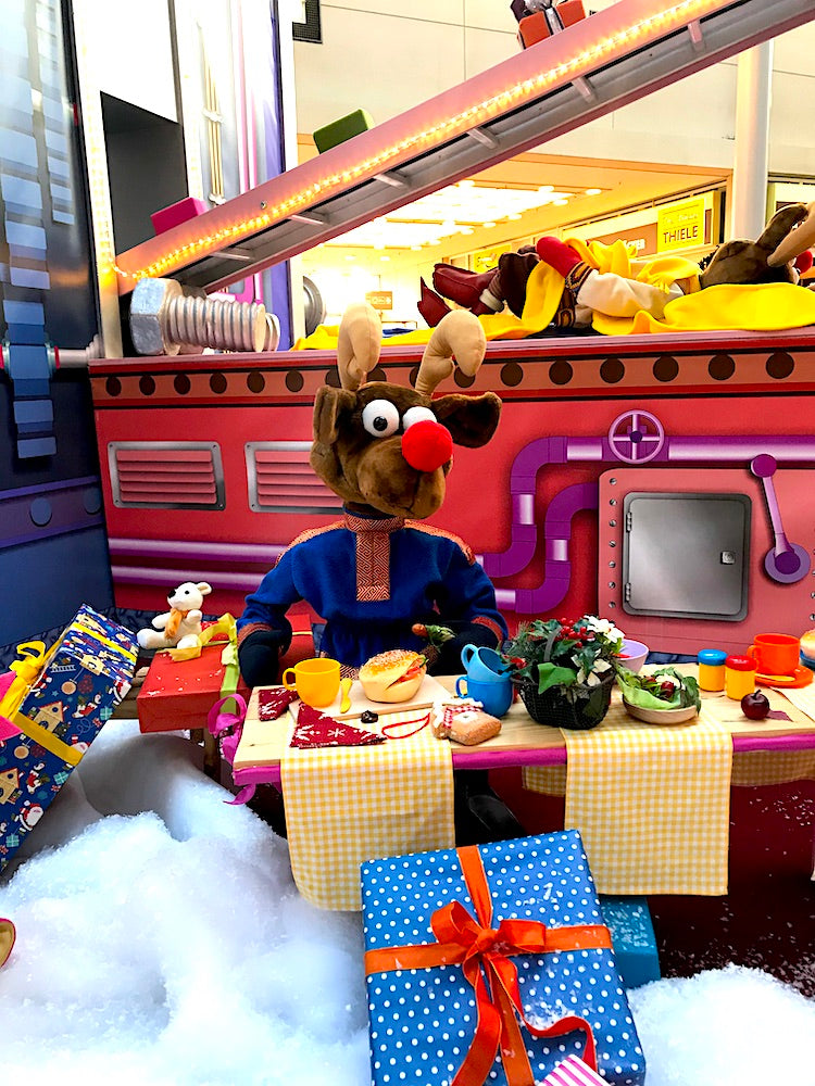 Rudis Rentiertrupp verpackt Weihnachtsgeschenke mit einer großen Maschine