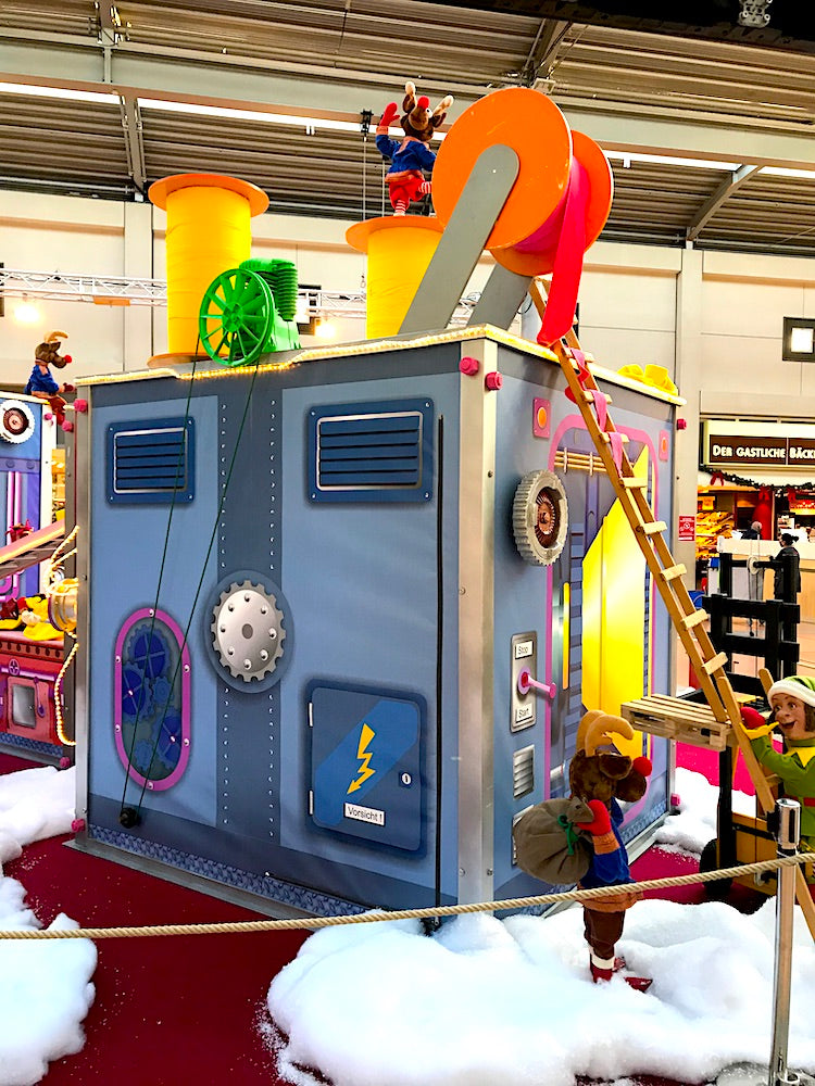 Rudis Rentiertrupp verpackt Weihnachtsgeschenke mit einer großen Maschine