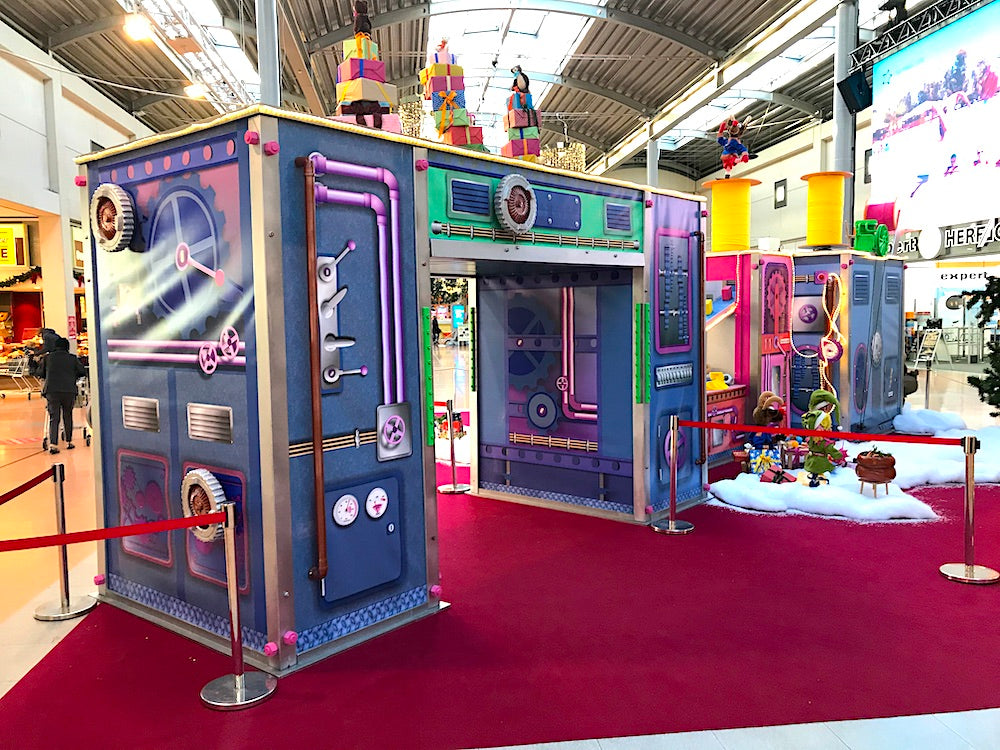 Rudis Rentiertrupp verpackt Weihnachtsgeschenke mit einer großen Maschine